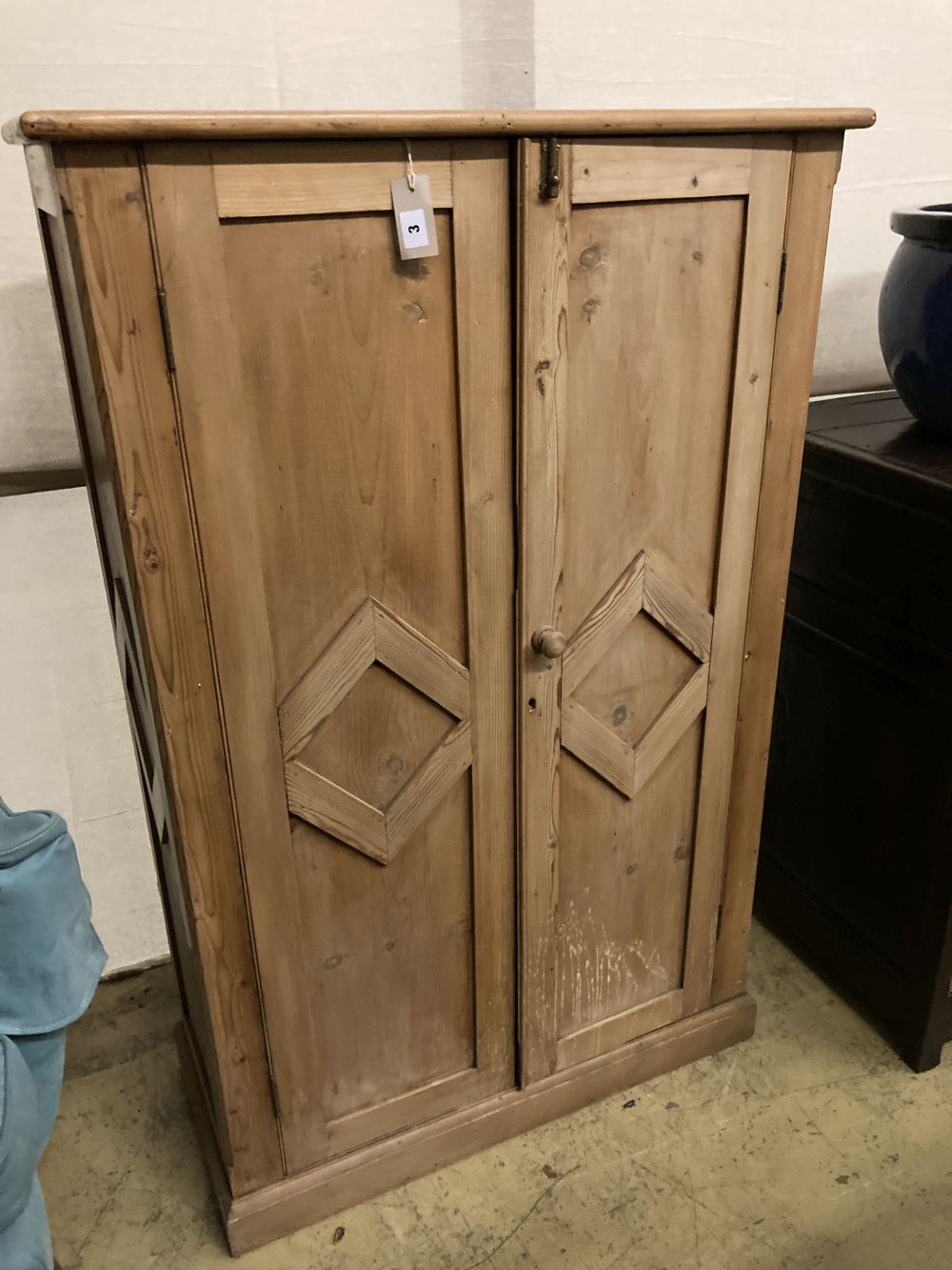 A collection of dolls and dolls house furniture displayed in room settings in a pine cupboard, width 84cm, depth 36cm, height 132cm